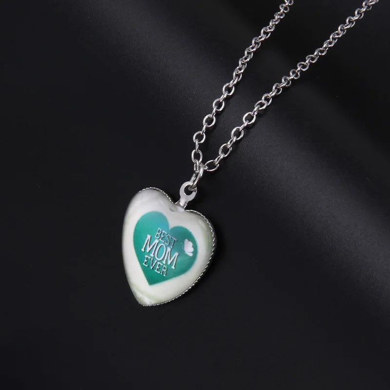 Heart-shaped pendant necklace with 'Best Mom Ever' text on a dark background