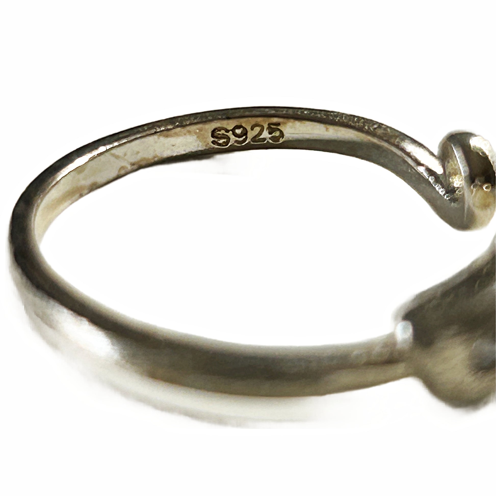 Close-up of a silver-toned ring band with an open end, showing the inner stamp 'S925' and a small gold-toned accent at the end, on a white background.