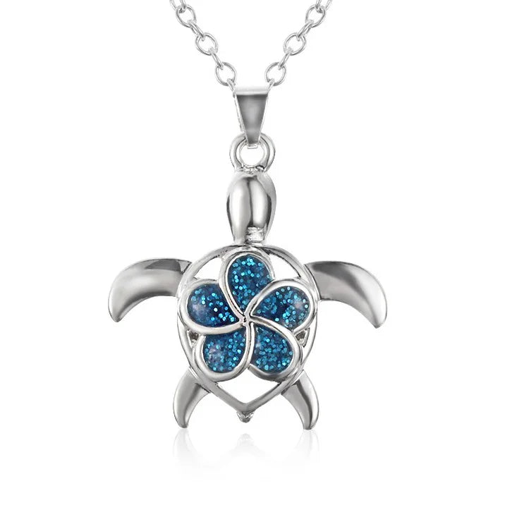 A sterling silver turtle pendant necklace featuring a blue glitter flower design on the shell, shown on a clean white background.