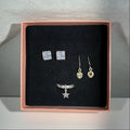 Jewelry set including earrings and a ring in a rose gold box on a gray background
