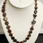 Necklace with heart-shaped brown stones on a white mannequin bust.