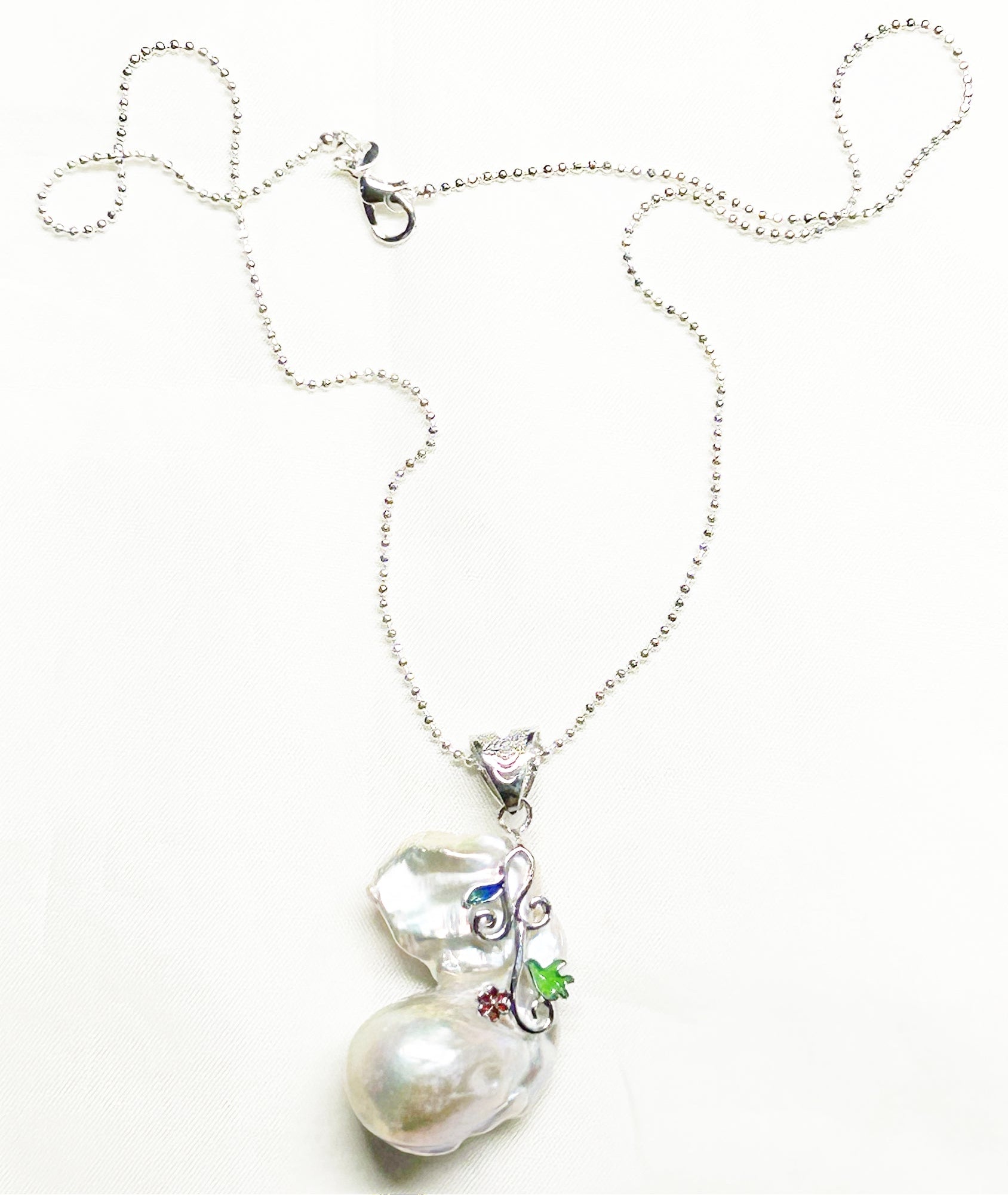 Pearl necklace with a silver chain on a white background