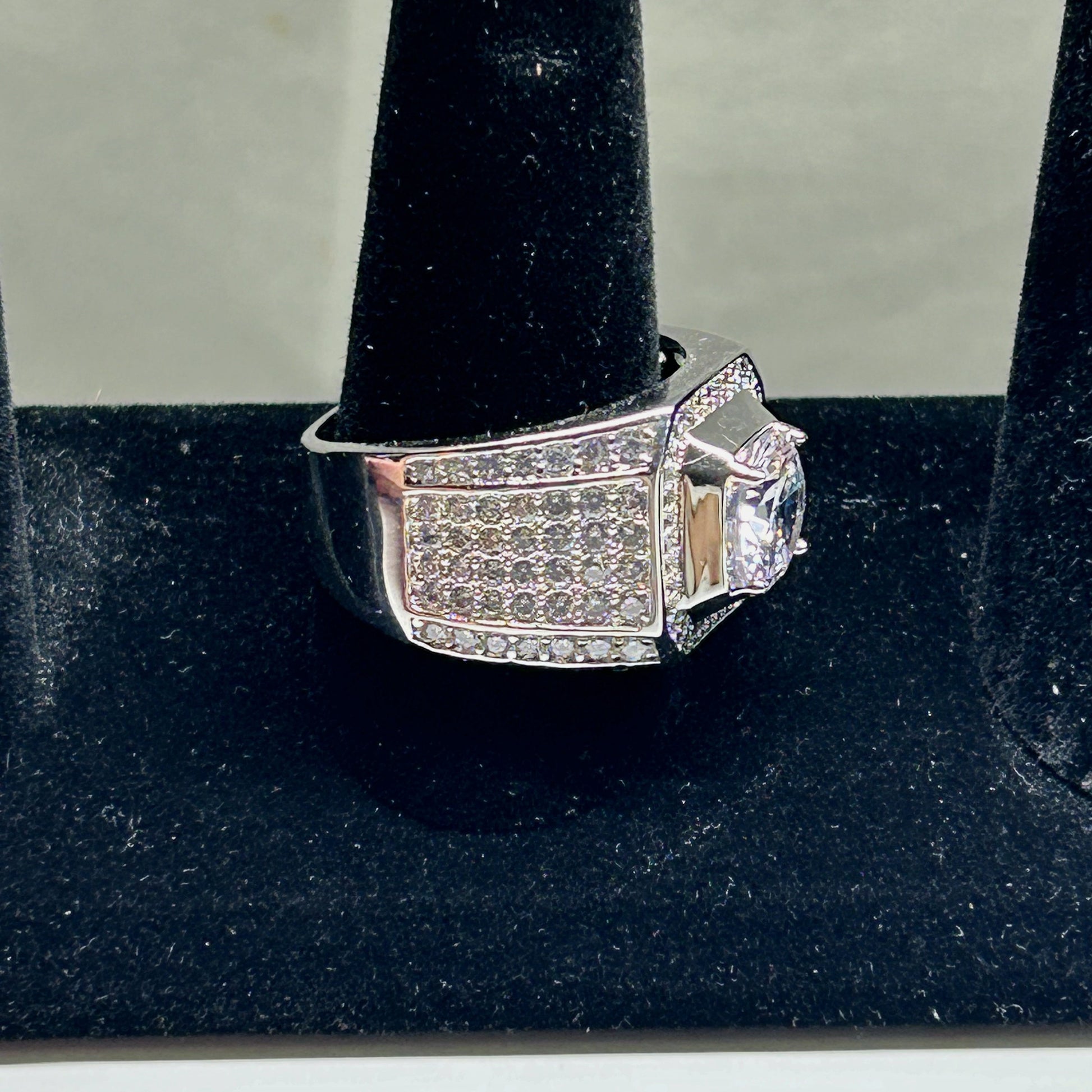 Silver ring with gemstones on a black stand