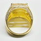 Gold ring with a large central stone and smaller stones on a white background