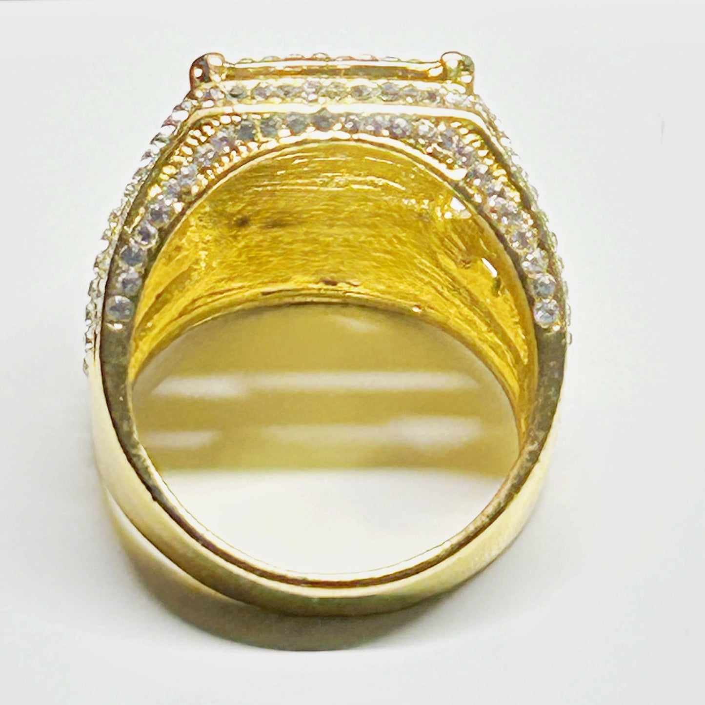 Gold ring with a large central stone and smaller stones on a white background