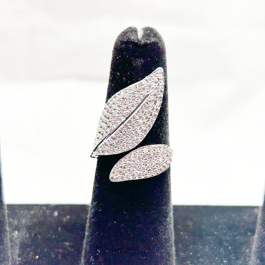 Silver leaf-shaped earring on a black stand with a white background