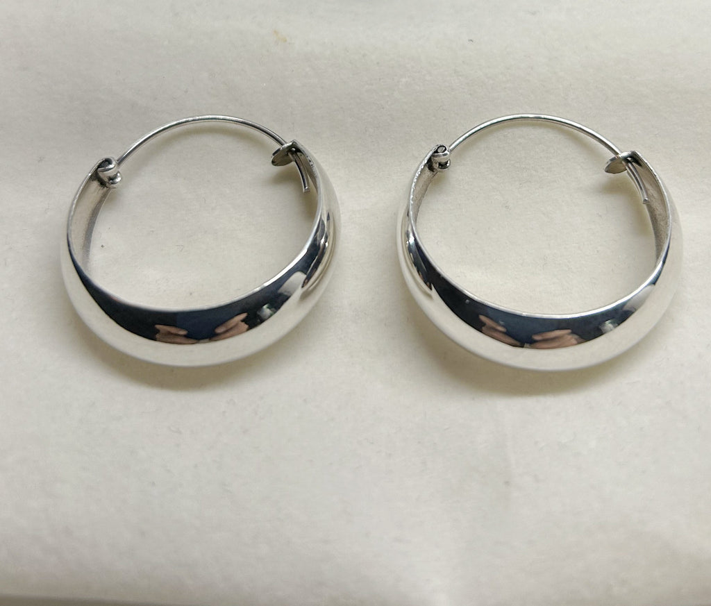 Pair of sterling silver hoop earrings on a light gray background