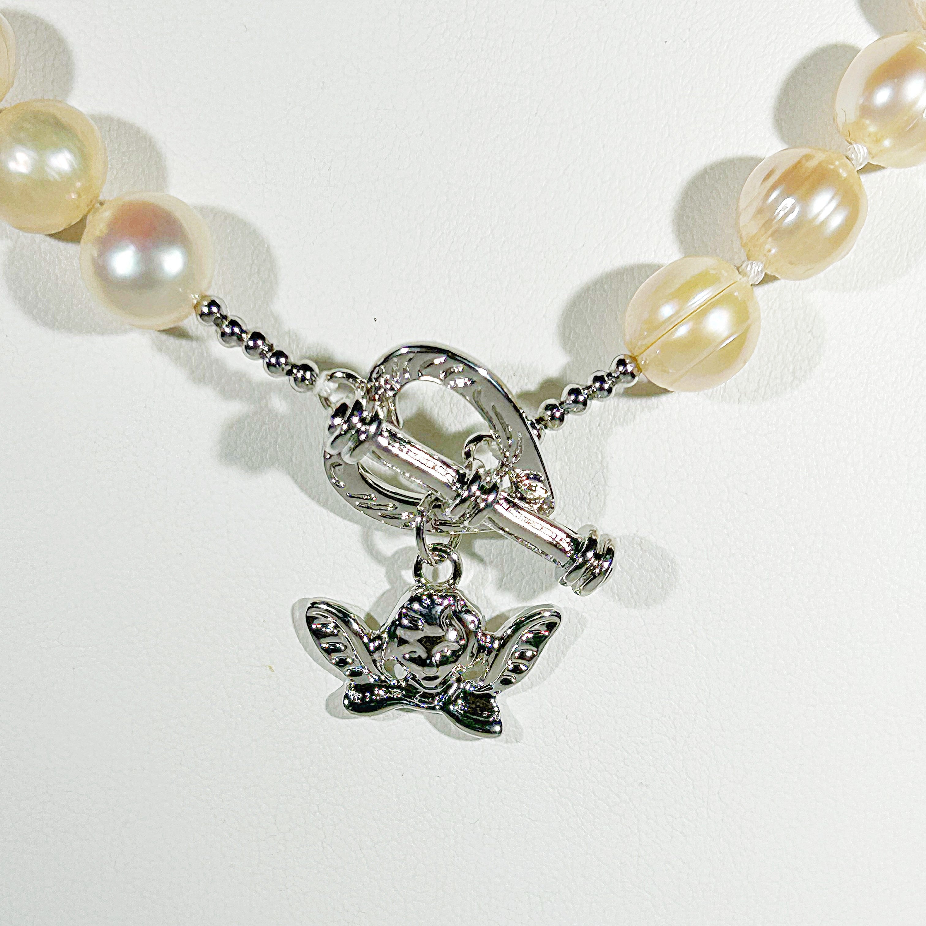 Pearl bracelet with a silver butterfly charm on a white background