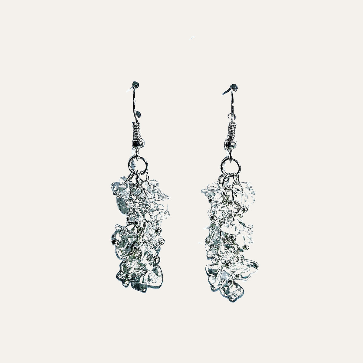 A pair of silver dangle earrings with organic, fluid, cloud-like textured drops, shown against a solid off-white background.