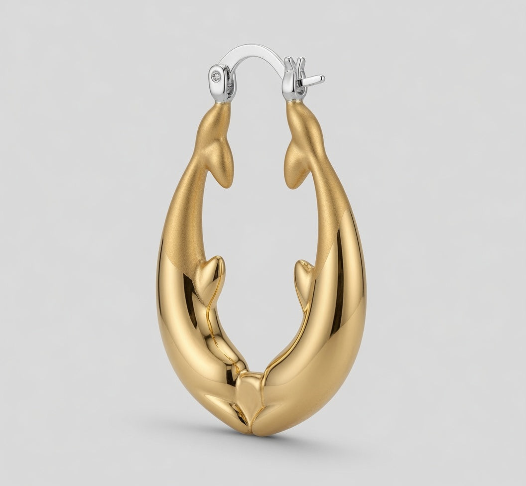 A pair of gold hoop earrings shaped like dolphins facing inward, with silver-tone fishhook ear wires at the top, shown on a light gray background.
