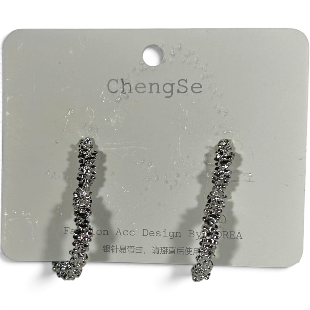 Providence Wholesale Silver heart-shaped hoop earrings with a rugged, textured metallic finish on a display card.