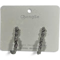Providence Wholesale Silver heart-shaped hoop earrings with a rugged, textured metallic finish on a display card.