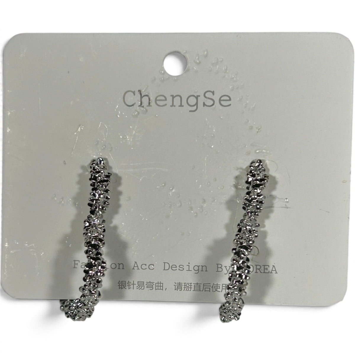 Providence Wholesale Silver heart-shaped hoop earrings with a rugged, textured metallic finish on a display card.