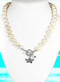 Pearl necklace with a silver butterfly charm on a white mannequin against a blue and green abstract background.
