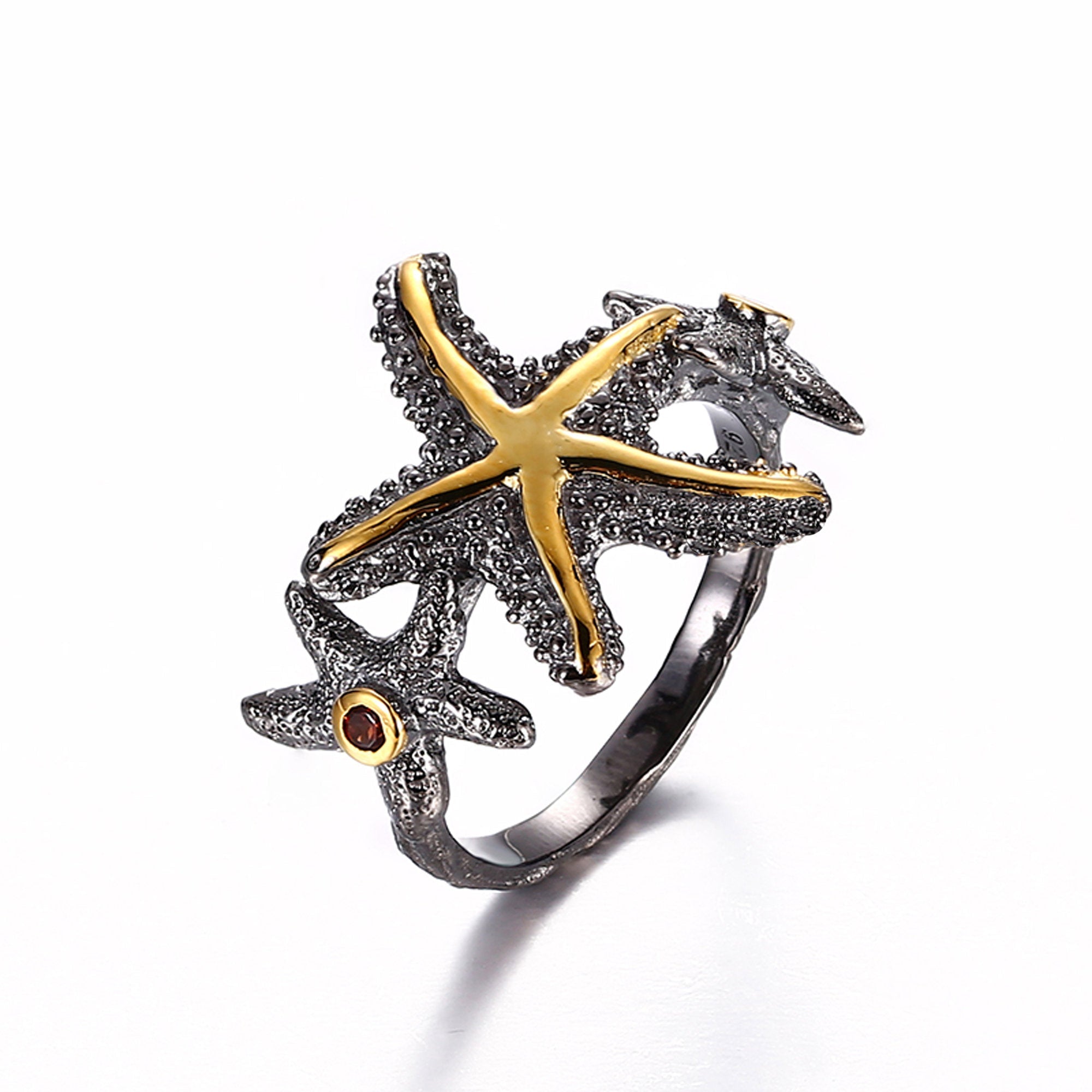 Handcrafted sterling silver starfish ring with 2 garnet gemstones on sides.